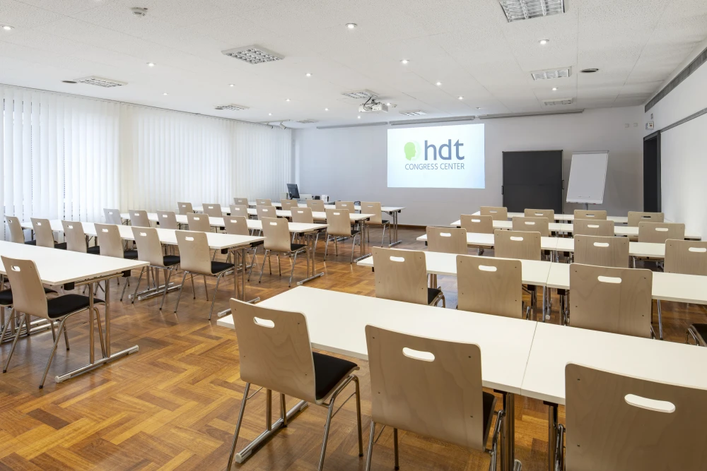 Heller Schulungsraum im HDT Congress Center Essen mit Projektionsfläche und moderner Ausstattung