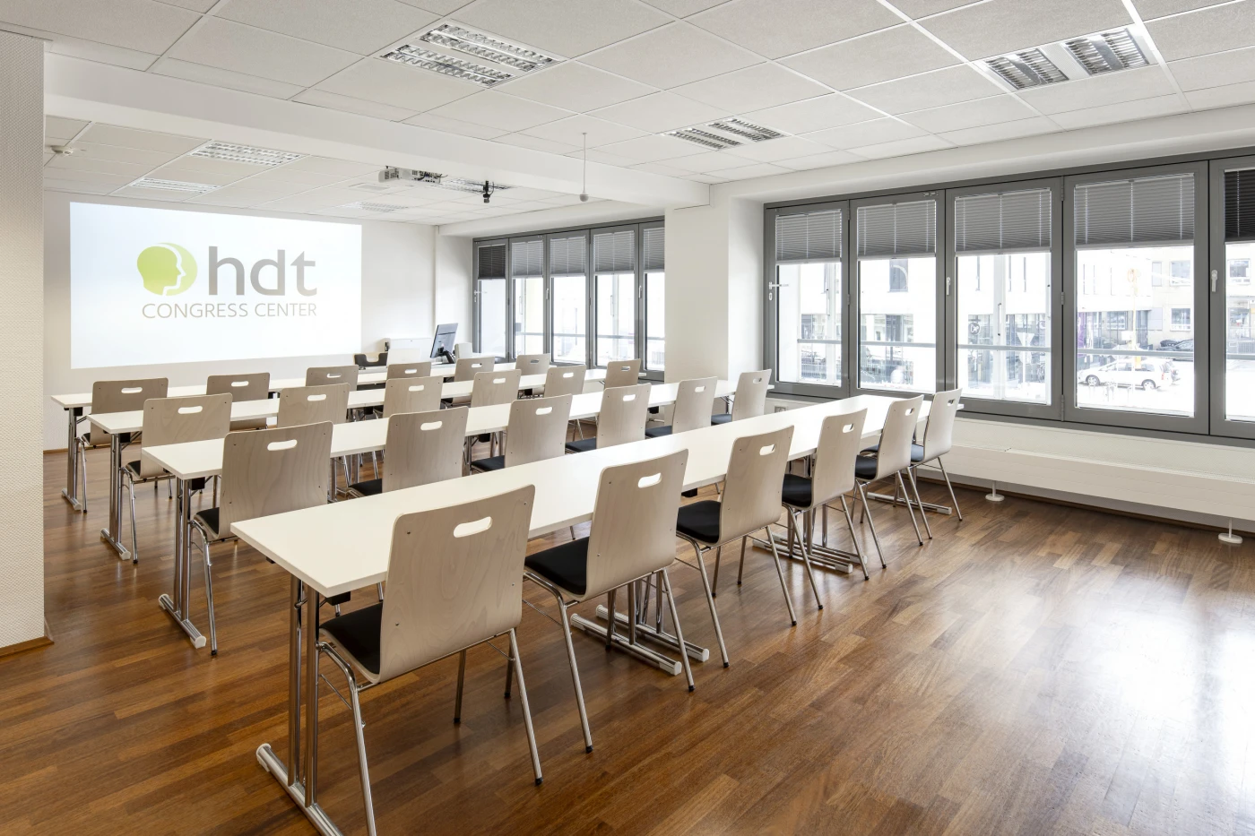 Moderner Schulungsraum im HDT Congress Center Essen mit Tageslicht und Beamerfläche.